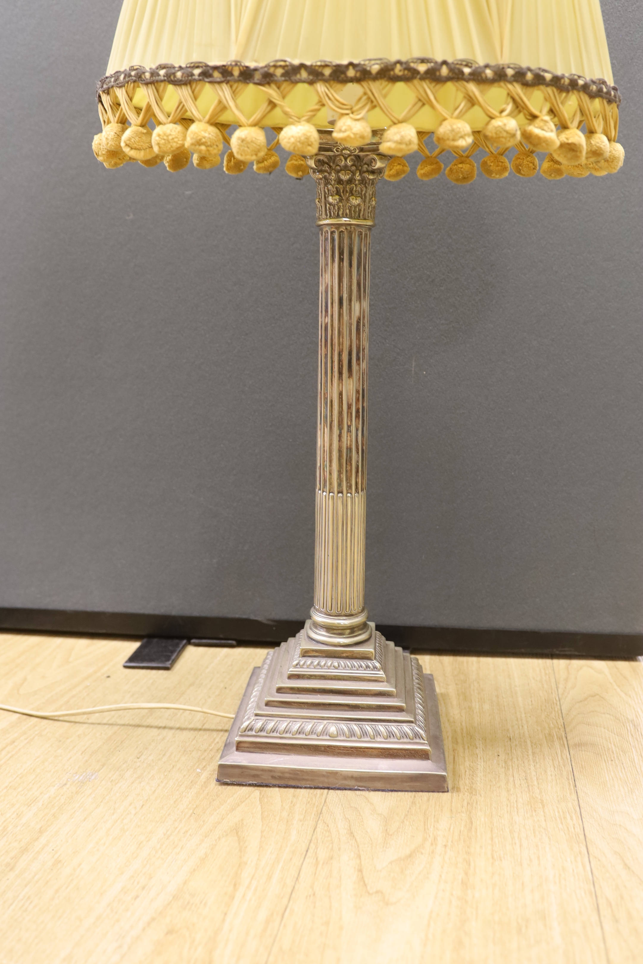 A tall silver plated Corinthian column desk lamp with shade, 75cm total